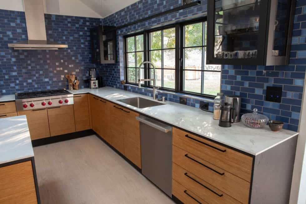 Scandinavian kitchens with tan cabinets and blue tile backsplash 