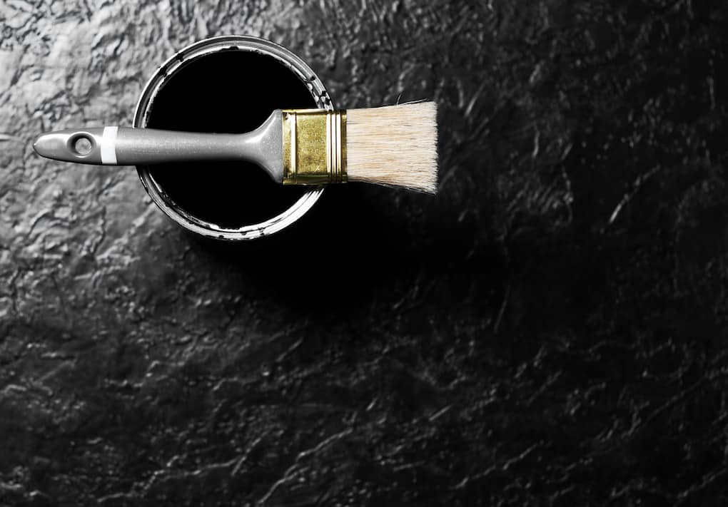 Brush and open can black color of paint on black background